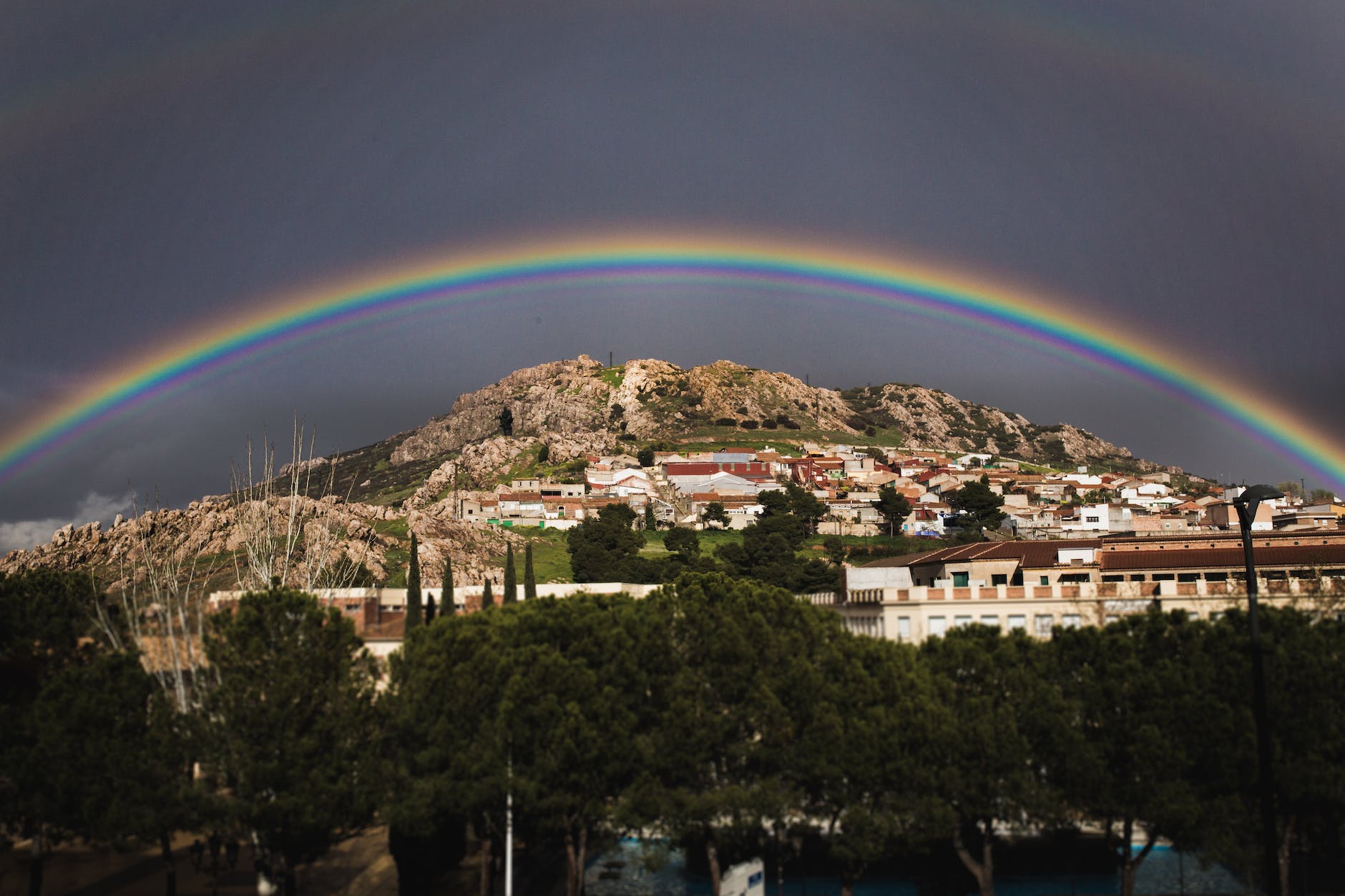 landscape photo of the view of city with rainbow above